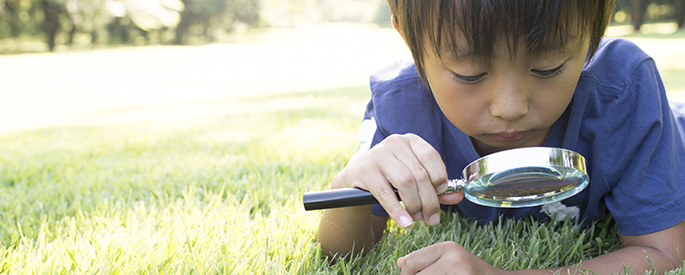 boy using magnifying glass